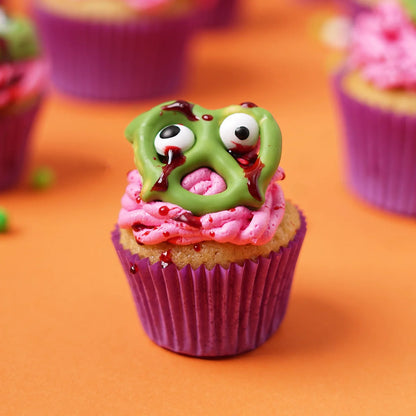 Halloween Themed Vanilla Cupcake decorated to resemble brains and chocolate coated 'zombie' pretzel.